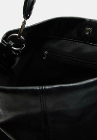 Černá kožená taška přes rameno s hladkým povrchem, vybavená stříbrným kovovým kroužkem a vnitřní kapsou na zip pro bezpečné uložení.