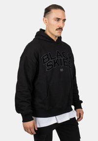 Black hoodie made of soft cotton, featuring a front pocket and bold "BLACK SKIES" logo in matte black across the chest.