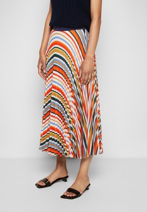 Femme portant une jupe midi plissée multicolore à motif rayé, un top noir sans manches et des sandales noires à petit talon.