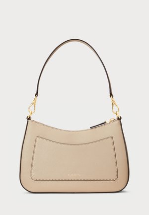 Beige handbag with a curved design, made from textured material, featuring a front pocket and a brown shoulder strap with gold hardware.
