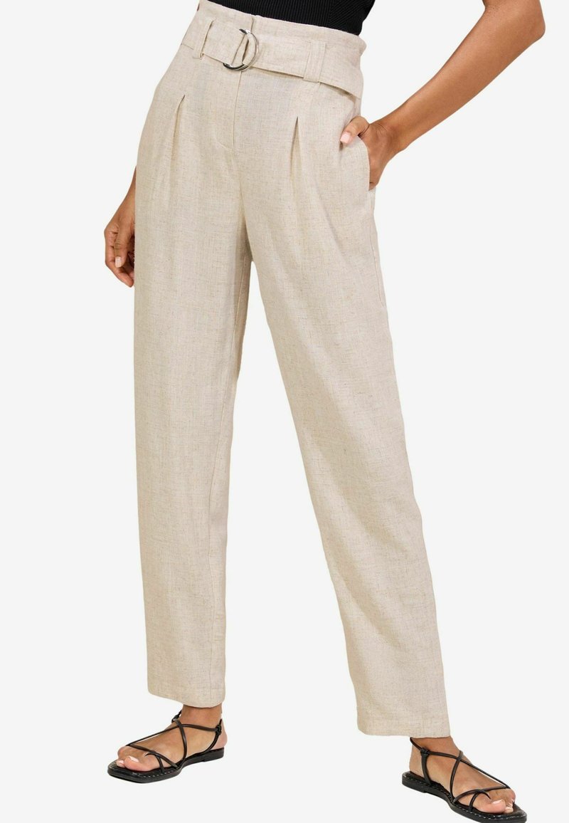 Pantalones de lino beige con un diseño de pierna ancha, pliegues en el frente, un cinturón con una hebilla plateada y bolsillos laterales, combinados con sandalias negras de tiras.
