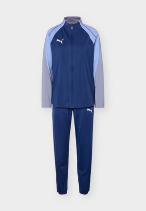 Pánska súprava značky Puma v námorníckej modrej a svetlosivej farbe so zapínaním na zips na celej dĺžke bundy a elastickými manžetami na nohaviciach.