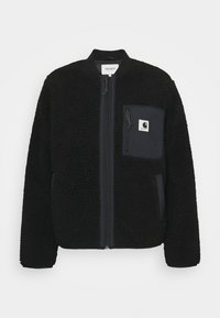 Mustaherkkä fleece-takki, jossa on vetoketju edessä, ribattu kaulus ja pieni rintatasku, jossa on valkoinen logopatch. Rakenne on pehmeä ja tekstuurinen.