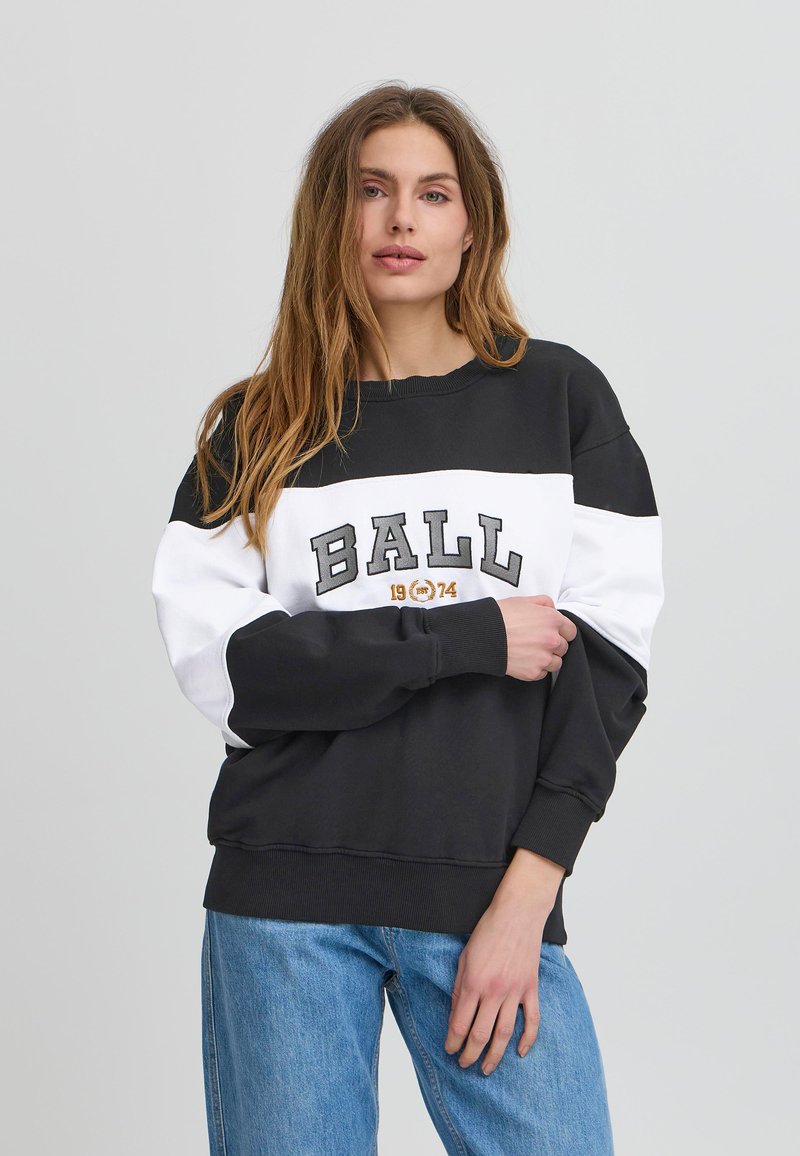 Sudadera a color blanco y negro con bloques de color y el texto "BALL" en negrita, con puños y dobladillo acanalados, hecha de una tela suave y de corte relajado.