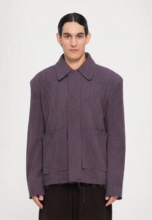 Lila texturierte Jacke mit breitem Kragen, zwei vorderen Taschen und fransigem Saum. Sie zeichnet sich durch eine lockere Passform und ein minimalistisches Design aus.