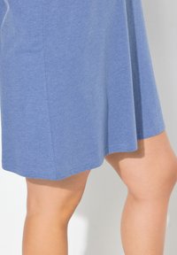 Niebieska sukienka z bawełny w składzie z luźnym krojem, długości do kolan i gładką teksturą. Posiada widoczne przeszycia wzdłuż brzegów.