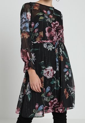 Robe noire à fleurs avec des manches longues, taille froncée et texture transparente. Présente des fleurs multicolores dans différentes teintes sur un tissu plissé.