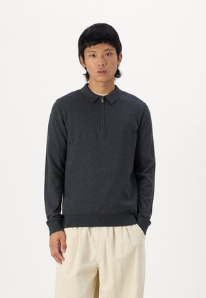 Gray zip-neck pullover made of soft fabric, featuring a polo collar, ribbed cuffs, and hem, worn with light beige trousers.