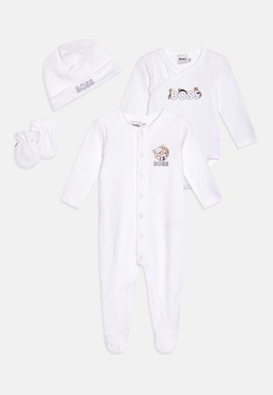 Ensemble de vêtements de bébé blanc comprenant un body avec fermeture à boutons, un bonnet et des moufles ; présente un texte brodé "BOSS" et un dessin de raton laveur.