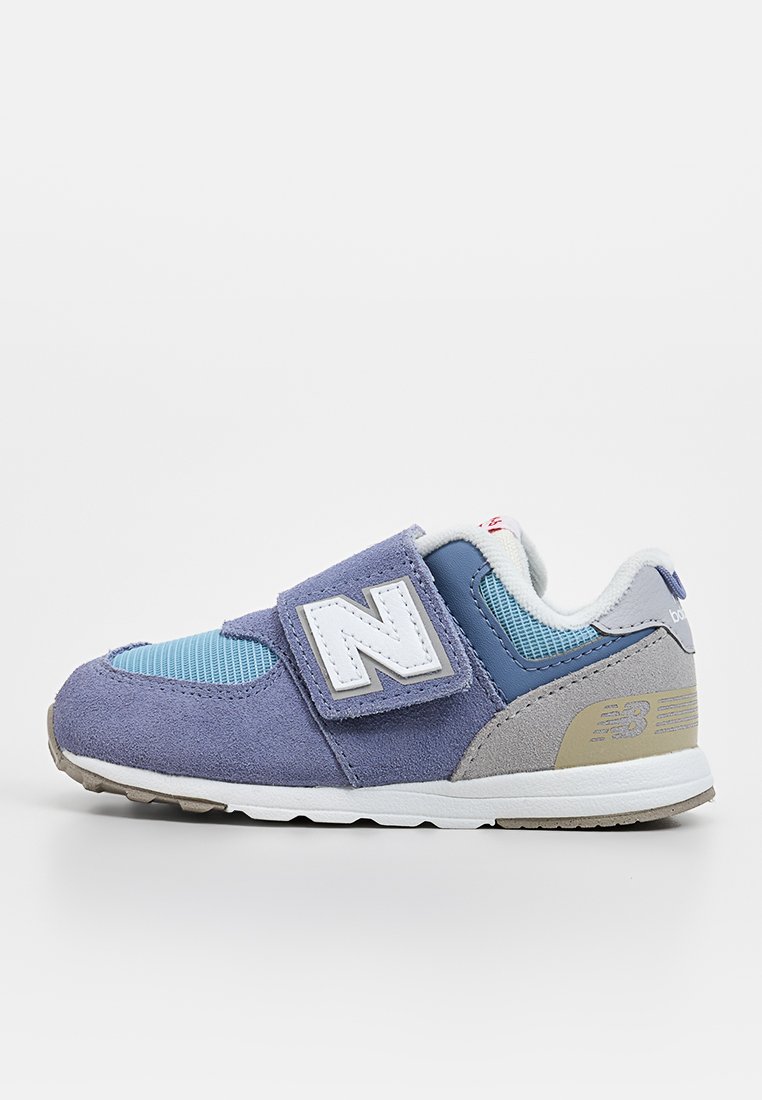 Leichter Sneaker mit einem Obermaterial aus lila Wildleder und blauen Mesh-Akzenten, ausgestattet mit einem Klettverschluss und einer gummierten Sohle. Logo an der Seite sichtbar.