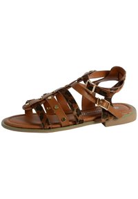 Sandal in pelle marrone con accenti in stampa leopardata, borchie dorate e cinturino alla caviglia regolabile. Suola piatta con design a punta arrotondata.