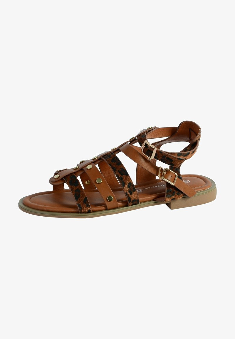 Sandale en cuir marron avec des accents en imprimé léopard, des clous dorés et une bride de cheville réglable. Semelle plate avec un design de bout rond.