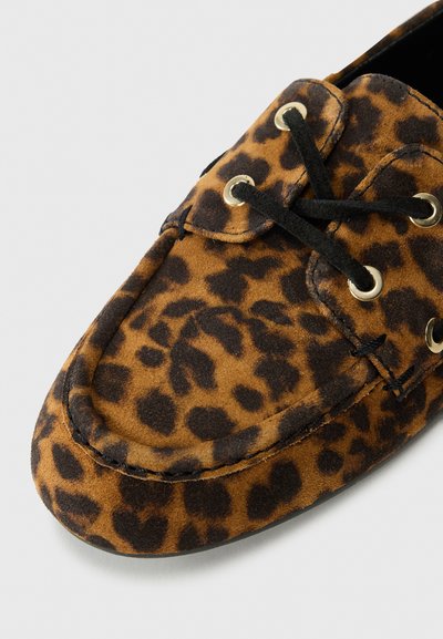 Mocassini con stampa leopardata marrone e nera in suede, con lacci neri e occhietti in tono oro. Punta rotonda e dettagli cuciti.