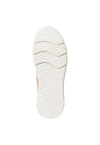 Semelle en caoutchouc blanche de sneaker présentant un motif de semelle ondulée et un logo circulaire. Design texturé avec un accent en suède beige sur le côté.