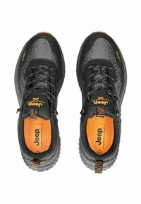 Černé a šedé sportovní boty s vrškem z prodyšné síťoviny, texturovanými akcenty, oranžovým vnitřním lemem a robustní podrážkou. Obsahují tkaničky a branding.
