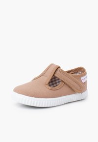 Chaussure pour tout-petit marron clair avec semelle en caoutchouc blanche et bride Velcro sur une doublure en tissu à carreaux.