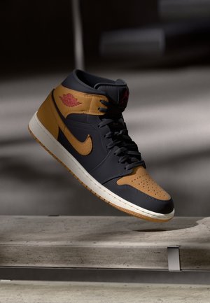 Czarno-brązowy, wysokogatunkowy but Air Jordan unoszący się nad betonową powierzchnią, z miękkim oświetleniem i rozmytym tłem.