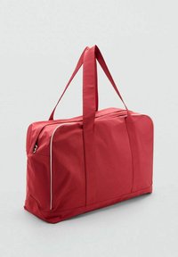 Sac de voyage rouge avec double poignées supérieures, de forme rectangulaire, fabriqué en tissu durable, avec des accents de fermeture éclair et de coutures blanches.