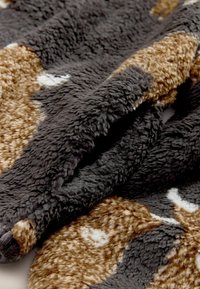 Soft, plush throw blanket featuring a textured surface in dark gray, brown, and cream with abstract patterns and a cozy, thick feel.