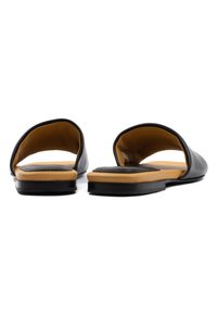 Sandali neri in pelle senza chiusura con retro aperto, caratterizzati da una tomaia liscia e una soletta a contrasto color tan; suola piatta.