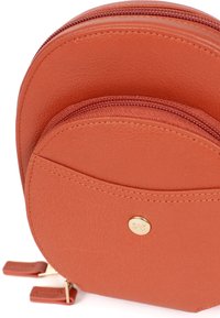 Borsa rotonda a due scomparti in pelle rugosa color ruggine. Dotata di hardware dorato, doppie cerniere e dettagli cuciti; design compatto e moderno.