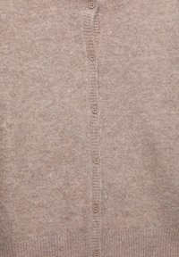 Beige knitted cardigan with a row of seven round buttons down the center front and ribbed hem.