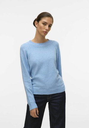 Pull en tricot bleu clair avec un col rond, des manches raglan longues et un ourlet côtelé. Associé à un jean noir. Texture lisse, design décontracté.