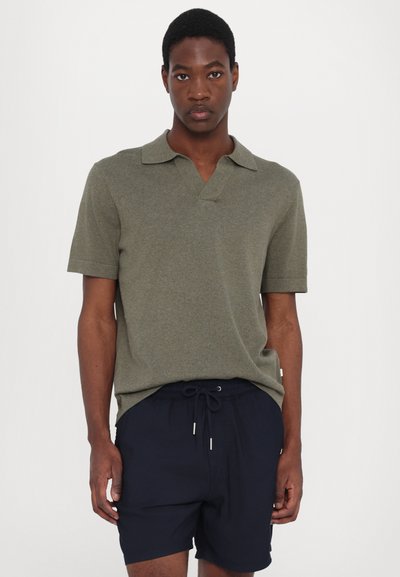 Polo de manga curta verde-oliva com gola em V e punhos dobrados, combinado com calções de drawstring azul-marinho. O tecido parece texturizado.