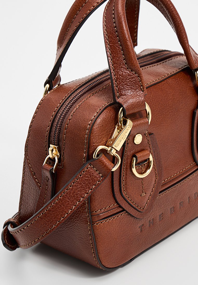 Braune Lederhandtasche mit strukturiertem Design, doppelten Obergriffen, einem abnehmbaren Riemen, goldenen Beschlägen und geprägtem Branding an der Seite.