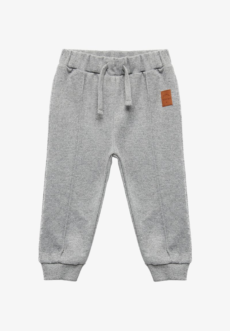 Ljusgrå stickade sweatpants med dragsko i midjan, ribbade muddar och en läderlapp på sidan. Strukturen på tyget är genomgående.
