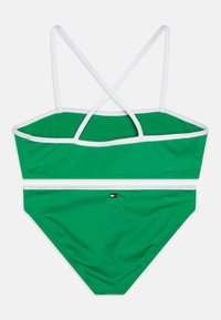 Set bikini verde con top corto caratterizzato da spalline bianche e design a X sulla schiena. La parte inferiore ha un colore verde uniforme con un piccolo logo decorativo.