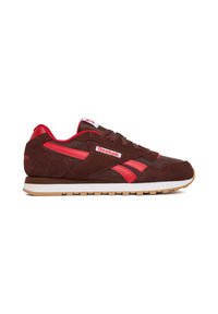 Braune Wildleder-Sneaker mit roten Akzenten, ausgestattet mit einer Gummisohle, Schnürdesign und dem Reebok-Logo an der Seite und auf der Zunge.