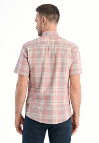 Korte mouwen geruit overhemd in rood en roomkleur met blauwe accenten. Lichtgewicht stoffen en een iets getailleerde pasvorm met een rugplooi.