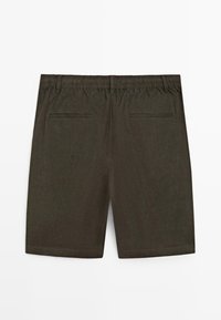 Mørke olivengrønne shorts med elastisk talje, bæltestropper og to baglommer med påsyede åbninger, vist fladt bagfra.