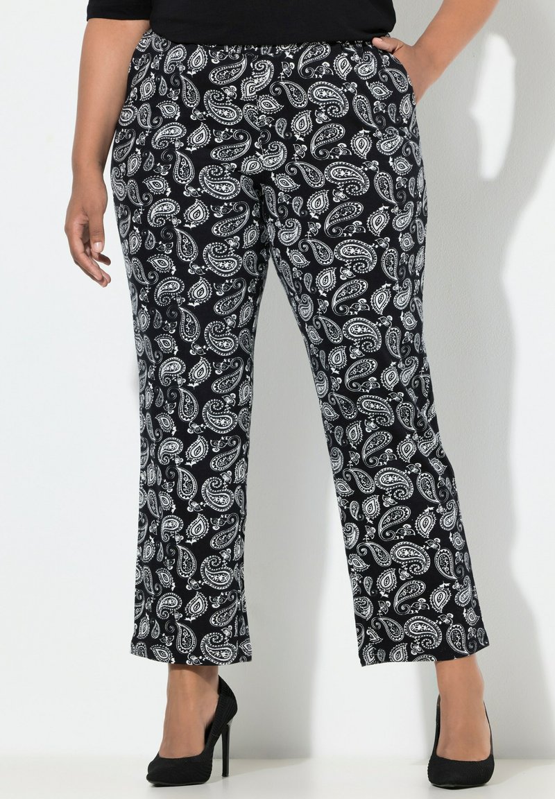 Černobílé kalhoty s paisley vzorem, elastickým pasem, rovnými nohavicemi a neformálním střihem, doplněné černými vysokými podpatky.