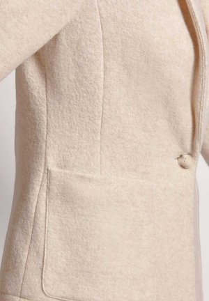 Beige Wollmischung-Blazer mit strukturierten Oberflächen, einem einzelnen Knopfverschluss und einer großen aufgesetzten Tasche auf der linken Seite.
