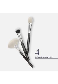 Three black-handled makeup brushes with white and black bristles labeled for face use, arranged next to text "4 The Face Specialists."