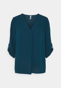 Blusa a maniche corte color teal con scollatura a V e design incrociato frontale. Presenta maniche arrotolate fissate con bottoni. Tessuto leggero.