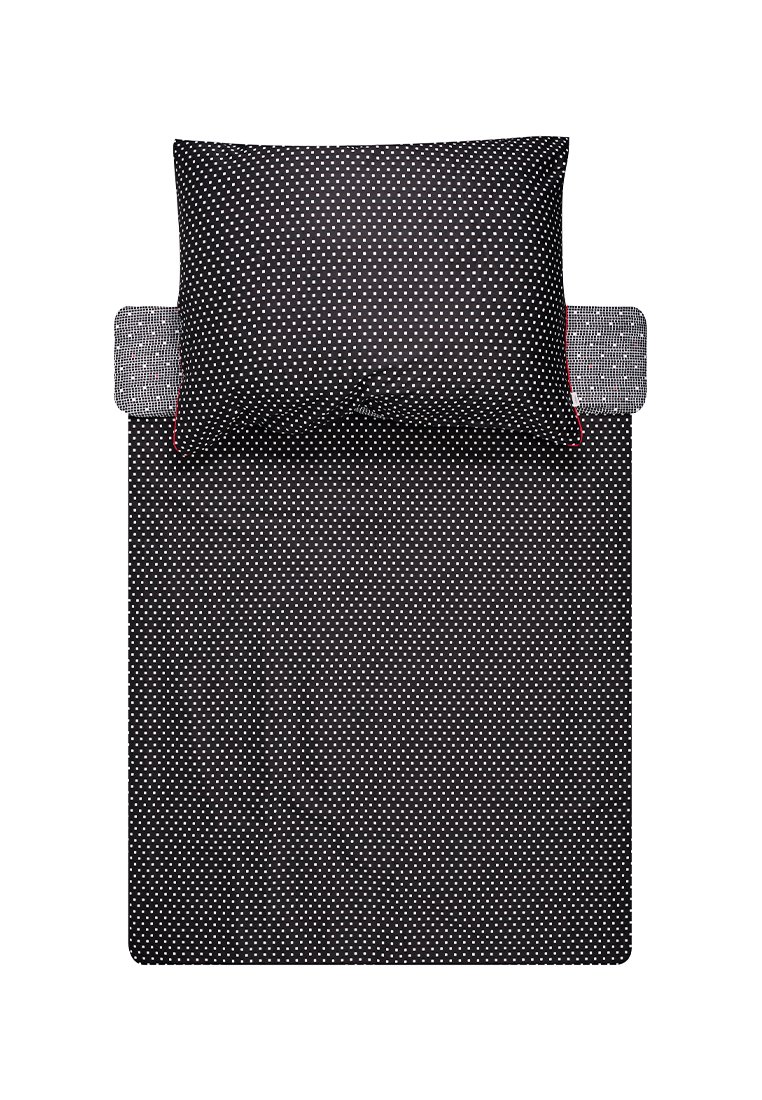 Linge de lit noir avec de petits pois blancs, comprenant un oreiller et un drap de lit plié avec un motif intérieur contrastant.