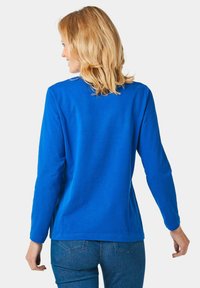 Langsleeve blauwe katoenen shirt met een ronde hals en een ontspannen pasvorm. Soepele textuur, licht gebogen zoom en casual stijl.