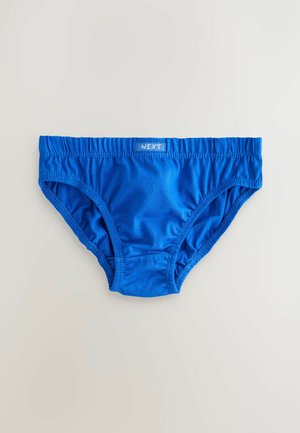 Slip en coton bleu avec ceinture élastique, présentant des coutures froncées sur les côtés et une petite étiquette portant l'inscription "NEXT."