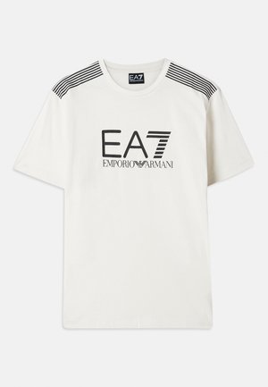 White t-shirt made of cotton with black "EA7 EMPORIO ARMANI" logo. Features black stripes on the shoulders and a standard crew neck design.