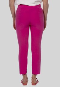 Getailleerde roze broeken met een zachte textuur, middellange taille en een slank ontwerp. Beschikt over twee achterzakken en een platte tailleband.