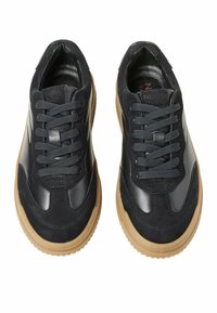 Scarpe sportive nere con tomaia in suede e pelle sintetica, suola in gomma texturizzata e lacci piatti. Caratterizzano un design elegante e moderno.