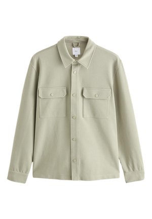 Lyse beige jakke med knapper, lange ærmer, to brystlommer med klapper og knapper samt klassisk krave.