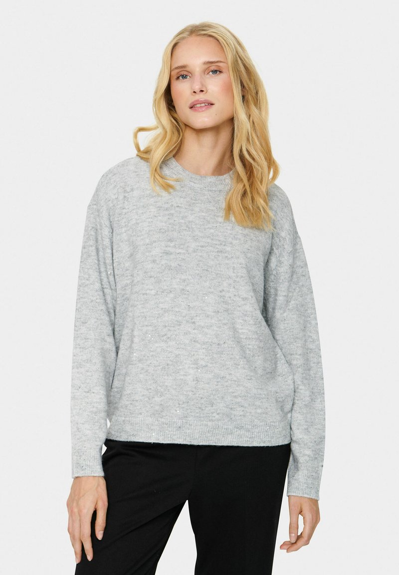 Jasnoszary sweter z dzianiny o okrągłym dekolcie, luźnym kroju i ściągaczach. Miękka faktura z delikatnymi wariacjami kolorystycznymi.