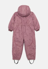 Mono acolchado rosa con capucha, que presenta patrones florales y puntos. Puños elásticos, una cinturilla ajustable y correas para los pies completan el diseño.