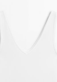 Witte mouwloze top met V-hals van gladde stof, close-up weergegeven op een effen achtergrond.
