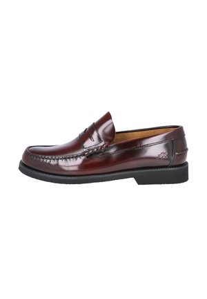 Mocasín tipo penny loafer de cuero marrón oscuro pulido, con suela negra, costura moc toe y pequeño logo en relieve en el lateral del talón.