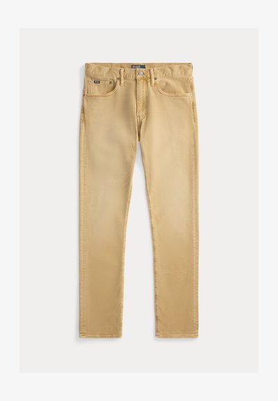 Μπεζ βαμβακερά τζιν παντελόνια με στενή γραμμή, σχέδιο πέντε τσεπών και ορατές ραφές. Διαθέτει μεταλλικό κουμπί και ετικέτα στη μέση.